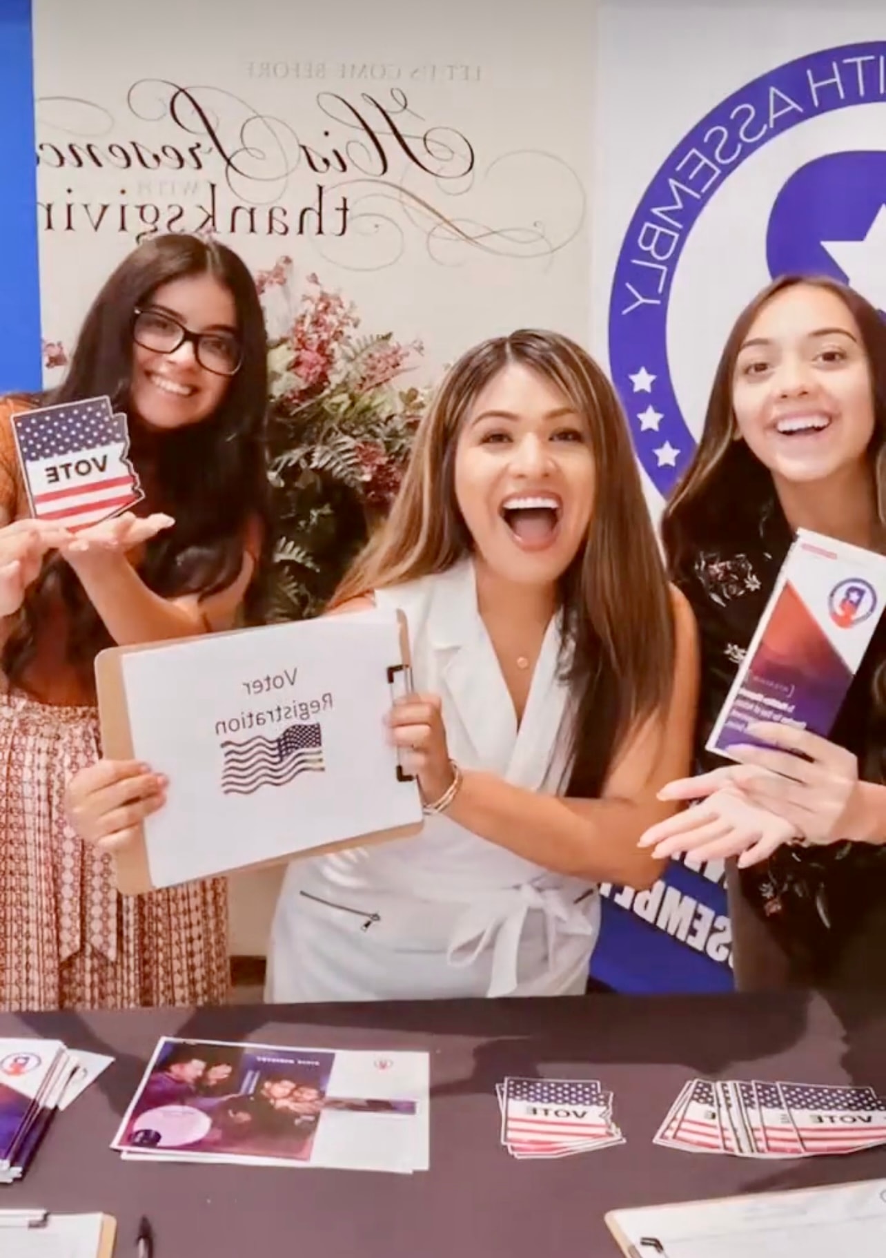 Team holding Bienvenido branded materials